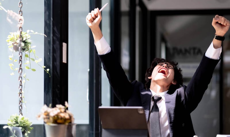 joven emocionado y celebrando su ascenso laboral