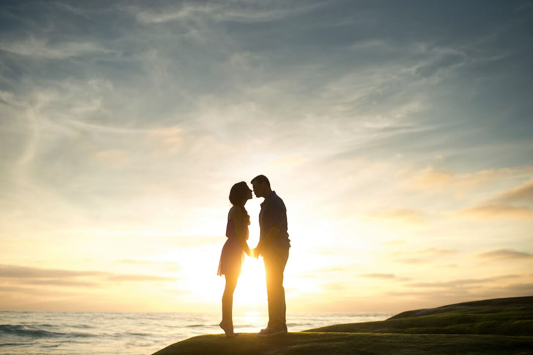 pareja besandose en el atardecer