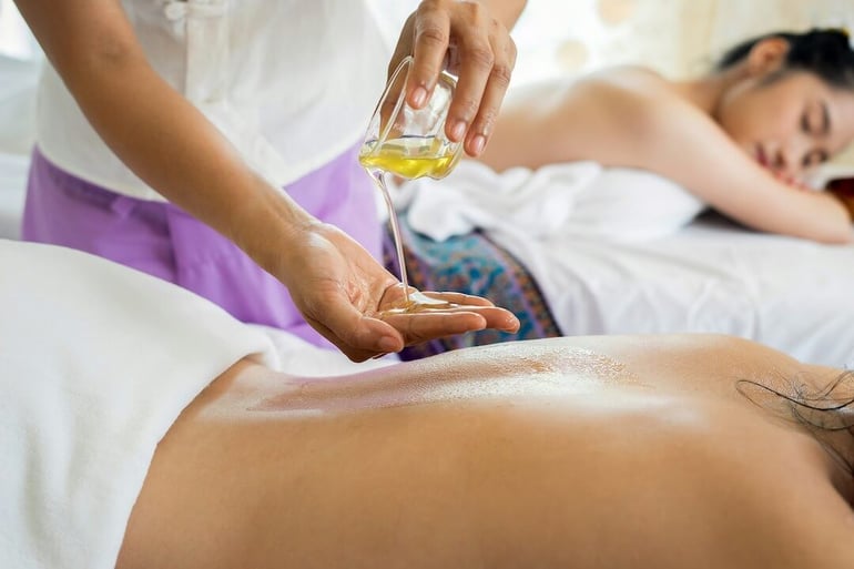 dos mujeres en un spa siendo masajeadas con aceite