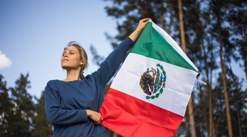 mujer sosteniendo bandera de mexico en festejo de fiesta patrias 